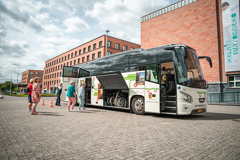 De Museum Plus Bus met open luiken en een buslift.